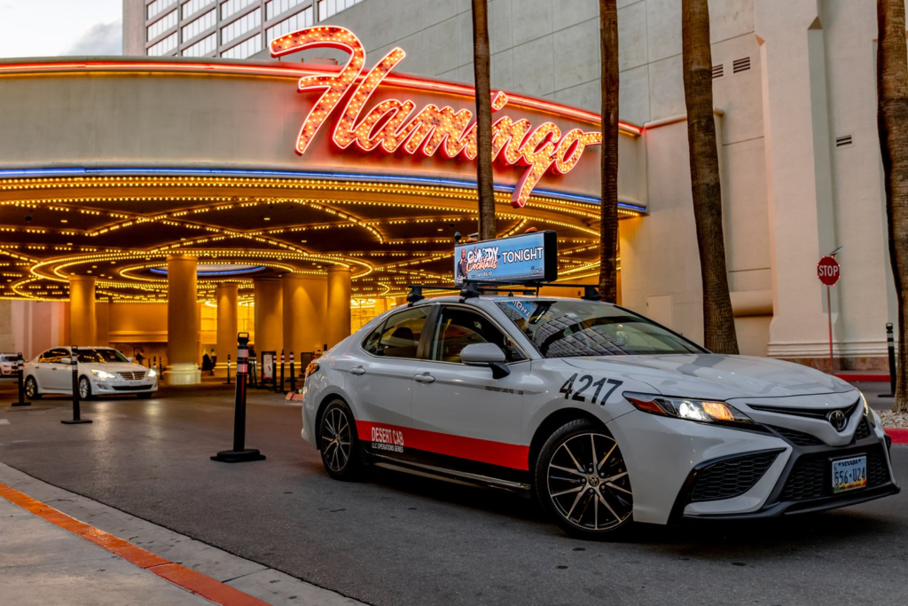 Car with a sign on the roof standing in front of a building